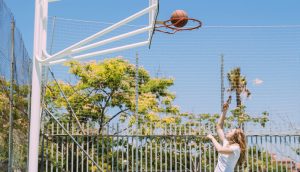 sportive-female-throwing-ball-into-hoop-nature-background